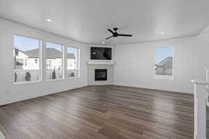 Living room with dark hardwood / wood-style flooring, a fireplace, and ceiling fan