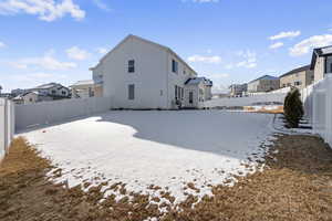 View of snow covered back of property