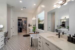 Modern, pristine primary bath with 2 separate sinks, makeup counter and garden tub