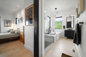 Bathroom featuring vanity, plus walk in shower, and hardwood / wood-style floors