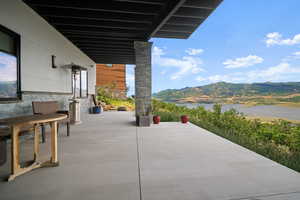 View of patio featuring a water and mountain view