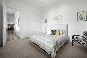 Bedroom featuring dark carpet and a closet