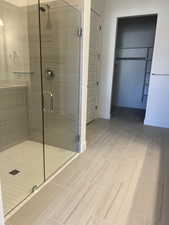 Primary Bathroom with walk-in shower, additional storage and walk-in closet