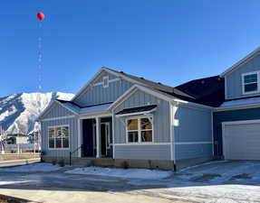 View of front of property with a garage and a mountain view