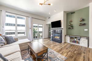 Living room with a tile fireplace, hardwood / wood-style flooring, and a chandelier