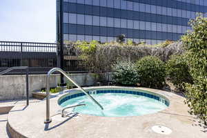 View of swimming pool with a hot tub