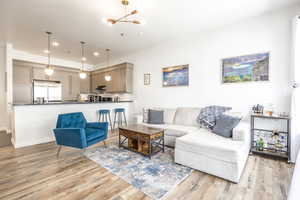 Living room with light hardwood / wood-style flooring and an inviting chandelier