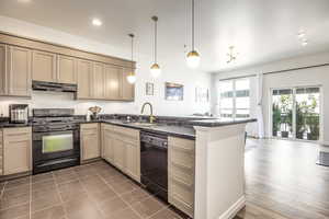 Kitchen featuring sink, pendant lighting, black appliances, and kitchen peninsula