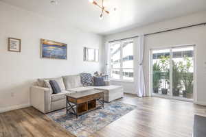 Living room with a notable chandelier and hardwood / wood-style floors