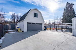 View of property exterior with a storage unit, central AC unit, and a garage