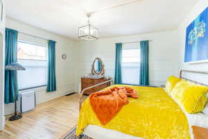 Bedroom with a chandelier and light wood-type flooring