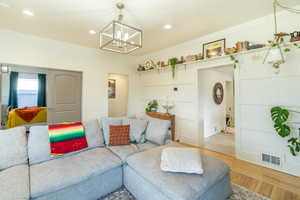 Living room featuring a notable chandelier and light wood-type flooring