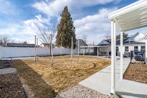 View of yard with a trampoline and a patio area