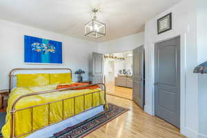 Bedroom featuring light hardwood / wood-style floors and a chandelier