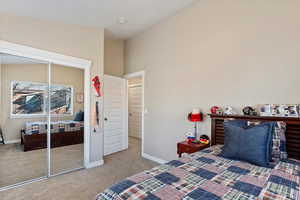 Carpeted bedroom featuring vaulted ceiling