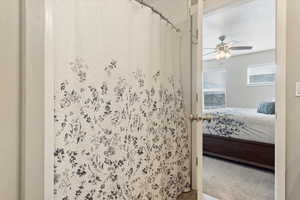 Bathroom with a shower with curtain and ceiling fan