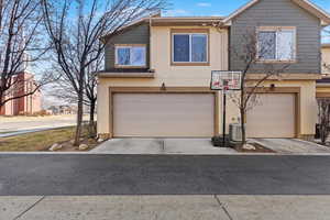 View of front of home with cooling unit and a garage