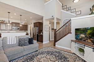 Living room with a towering ceiling and light hardwood / wood-style flooring