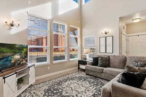 Living room with hardwood / wood-style flooring and a towering ceiling