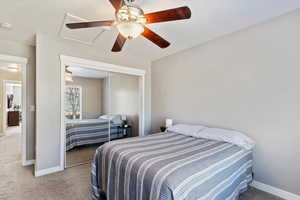 Carpeted bedroom with a closet and ceiling fan