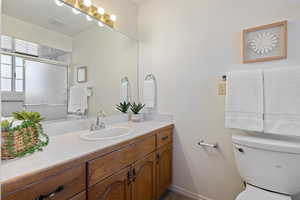 Bathroom featuring vanity, toilet, and walk in shower