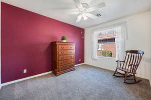 Sitting room with a textured ceiling, carpet floors, and ceiling fan