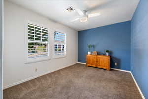 Empty room featuring ceiling fan, carpet floors, and a textured ceiling