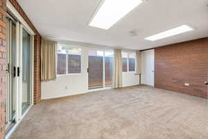 Carpeted empty room with brick wall