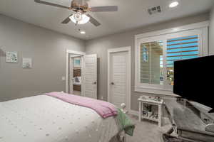 Bedroom with light colored carpet, a closet, and ceiling fan