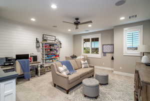 Carpeted home office featuring ceiling fan