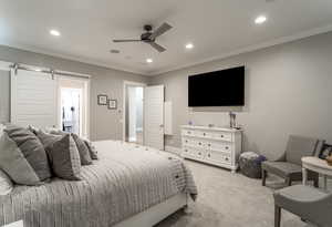 Bedroom featuring crown molding, light colored carpet, a barn door, and ceiling fan