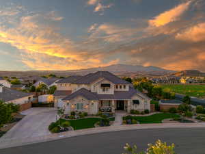 View of front of house with a garage, a mountain view, and a lawn