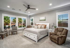 Carpeted bedroom with multiple windows, crown molding, and ceiling fan