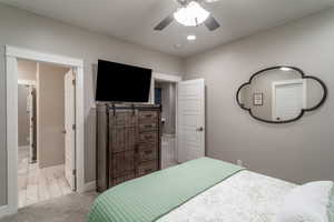 Bedroom with ceiling fan and light carpet