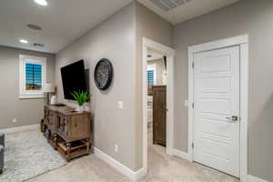 Corridor with light colored carpet