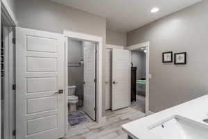 Bathroom with vanity, toilet, and hardwood / wood-style floors