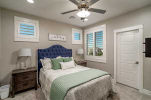 Carpeted bedroom featuring ceiling fan