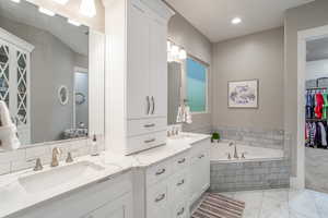 Bathroom featuring vanity and tiled tub