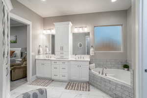 Bathroom with vanity and tiled tub