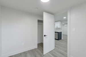 Unfurnished bedroom with light wood-type flooring and a closet