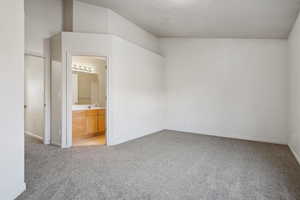 Unfurnished bedroom featuring light carpet, sink, and connected bathroom