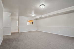 Unfurnished room featuring carpet floors, a textured ceiling, and ornamental molding