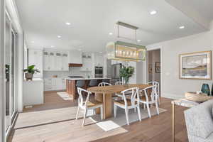 Dining area with light hardwood / wood-style flooring