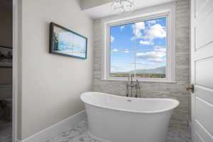 Bathroom featuring a mountain view, a bathtub, and toilet