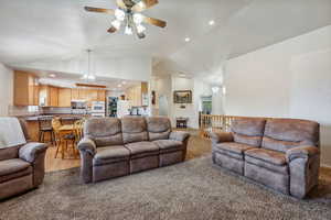 Living room with light carpet, sink, vaulted ceiling, and ceiling fan