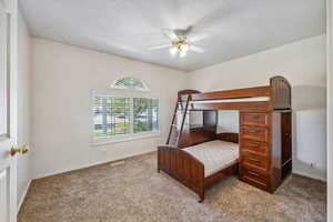 Carpeted bedroom featuring ceiling fan