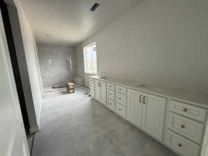 Full bath with double vanity, a sink, and a shower stall