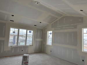 Empty room with vaulted ceiling