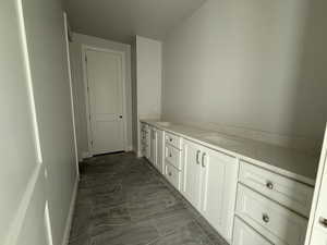 Hall featuring baseboards and a sink