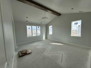 Spare room featuring lofted ceiling with beams, baseboards, and visible vents
